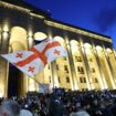 Un manifestant brandit le drapeau de la Géorgie lors d'un rassemblement contre le projet de loi controversé sur "l'influence étrangère" à Tbilissi le 14 mai 2024.