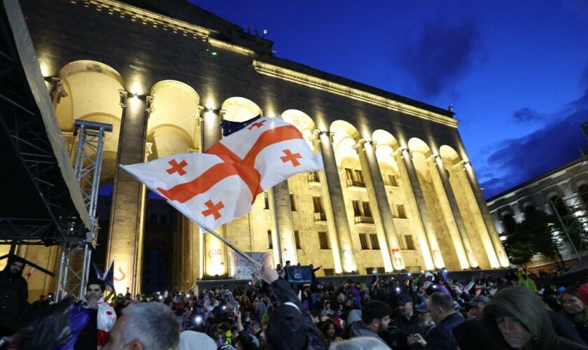 Un manifestant brandit le drapeau de la Géorgie lors d'un rassemblement contre le projet de loi controversé sur "l'influence étrangère" à Tbilissi le 14 mai 2024.