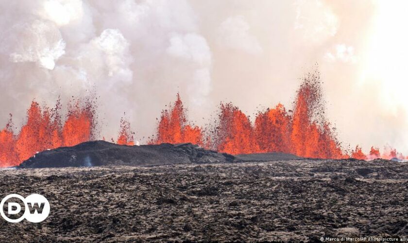 Billowing smoke and flowing lava pouring out of a volcanic fissure