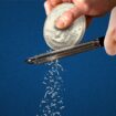 A chef grates a giant quarter coin as though it is Parmesan cheese