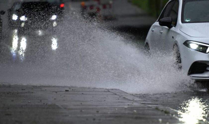 Ein Auto fährt durch eine große Wasserlache. Foto: Federico Gambarini/dpa