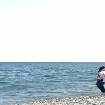 Two men mourn at the water's edge