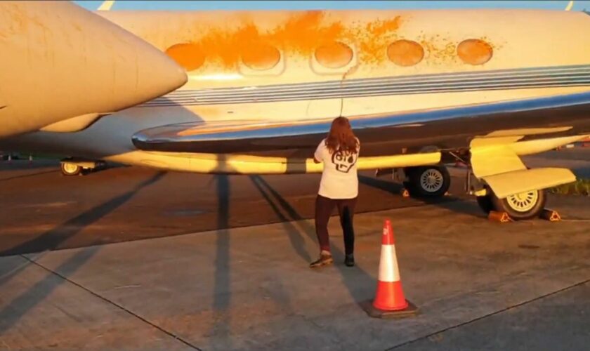 An image from a handout video of Just Stop Oil protesters spraying orange paint over private jets at Stansted Airport. Pic: PA