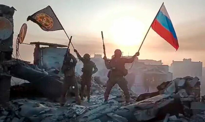 FILE - In this image from video provided by Prigozhin Press Service on Saturday, May 20, 2023, Yevgeny Prigozhin's Wagner Group military company members wave a Russian national and Wagner flag atop a damaged building in Bakhmut, Ukraine. Yevgeny Prigozhin's armed revolt against Russia's military leadership posed the greatest challenge to Vladimir Putin's authorities in his 23-year rule. (Prigozhin Press Service via AP, File)