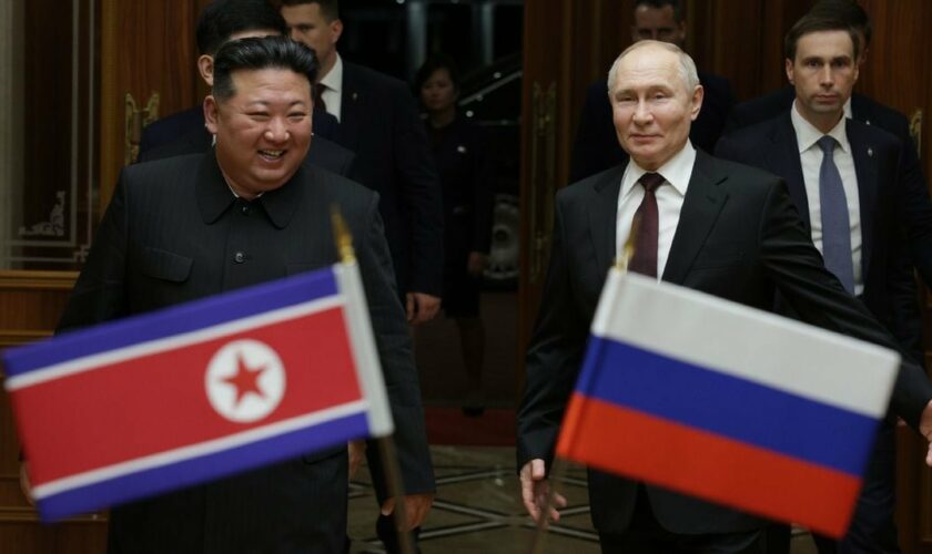 Le dirigeant nord-coréen Kim Jong Un (g) marche avec le président russe Vladimir Poutine lors d'une cérémonie de bienvenue à l'arrivée de ce dernier à Pyongyang, au début du 19 juin 2024