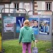 Une femme regarde les affiches électorales des candidats aux législatives à Wissembourg, le 30 juin 2024 dans le Bas-Rhin