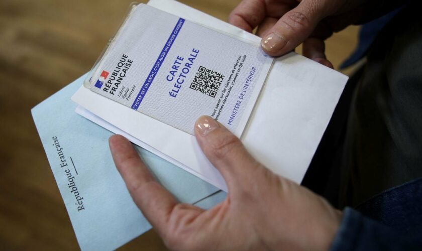 Une électrice attend pour déposer son bulletin de vote lors du 1er tour des législatives, le 30 juin 2024 à Toulouse, en Haute-Garonne