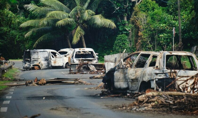 Des véhicules calcinés sur une route traversant la commune de Mont-Dore, en Nouvelle-Calédonie, le 10 juin 2024