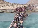 Disbelief in Greece as terrified tourists are told to disembark from ferry into the SEA and wade through neck-deep water to reach beauty spot after officials banned use of floating platform