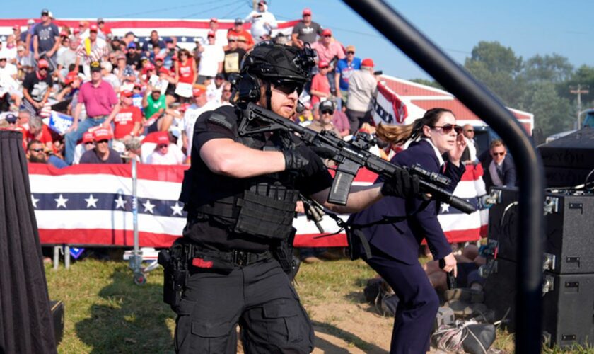 Secret Service agents rush the stage. Pic: AP