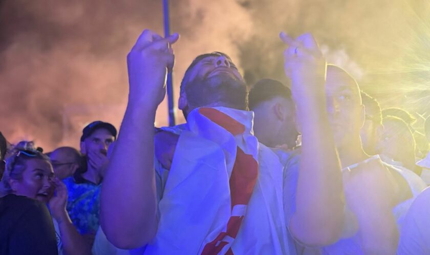 England fans cross their fingers and hope for victory in a fan zone in Berlin