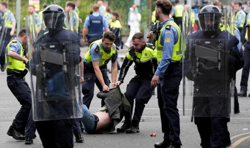 Officers detain a protester after violence at the former site of the Crown Paints factory in Coolock, north Dublin. Pic: PA