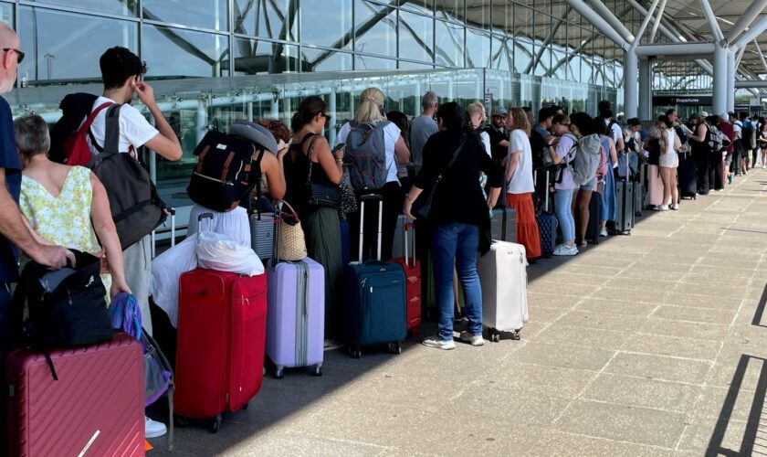 Passengers queue outside Stansted Airport amid the global outage. Pic: PA