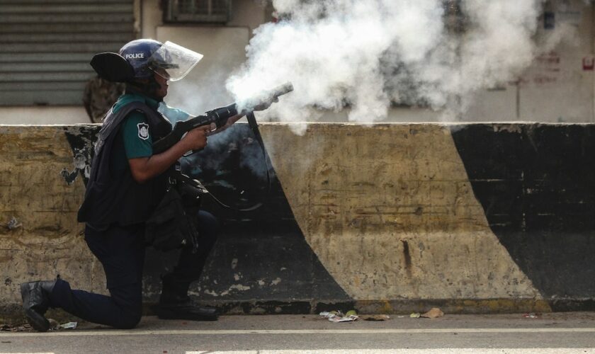 Un policier tire des gaz lacrymogènes sur des manifestants opposés aux quotas dans la fonction publique, le 19 juillet 2024 à Dacca, au Bangladesh