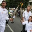 Press agency photographer Christina Assi, right, holds the Olympic torch with. Nicolas Payeur, left, at the 2024 Summer Olympics, Sunday, July 21, 2024, in Vincennes, outside Paris, France. Assi was struck by a tank shell on Oct. 13, 2023 while reporting clashes between the Israeli army and armed groups in southern Lebanon. (AP Photo/Thomas Padilla)