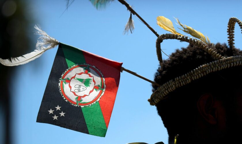 FILE - A performer in traditional dress stands before a welcome ceremony in Port Moresby, Papua New Guinea, Nov. 16, 2018. At least 26 people has been reported killed by a gang of men in three remote villages last week in Papua New Guinea's north, United Nations and police officials said on Wednesday, July 24, 2024. (AP Photo/Mark Schiefelbein, File)