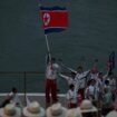 North Korean delegates wave their flag as they travel along the River Seine ahead of the opening ceremony in Paris. Pic: Reuters