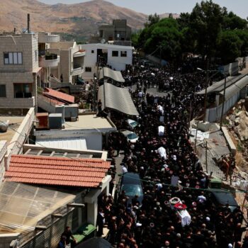 Coffins are carried through the streets of Majdal Shams in Golan Heights. Pic: Reuters