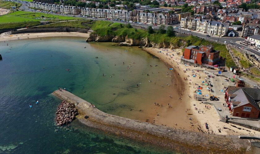 People enjoy the sunshine at Cullercoats Bay on North Tyneside. Pic: PA