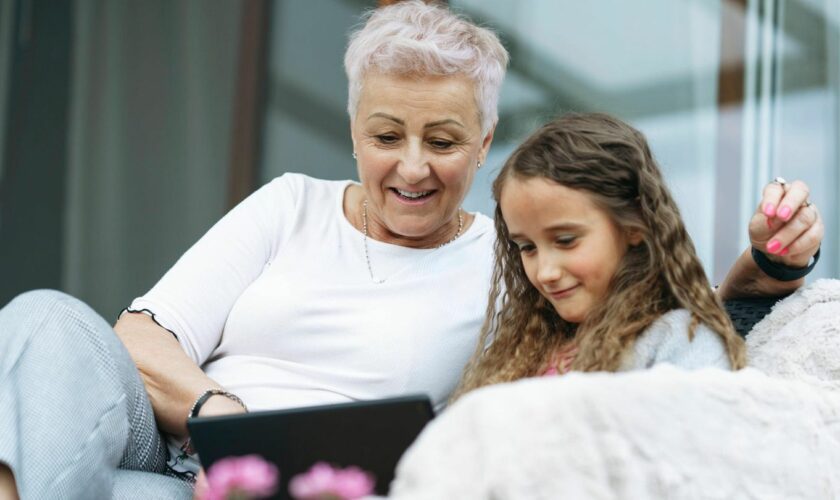 Oma und Enkelin schauen aufs Tablet