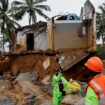 A volunteer throws a bottle of water to a man during rescue operations after several landslides hit the hills in Wayanad district, in the southern state of Kerala, India, July 31, 2024. REUTERS/Francis Mascarenhas