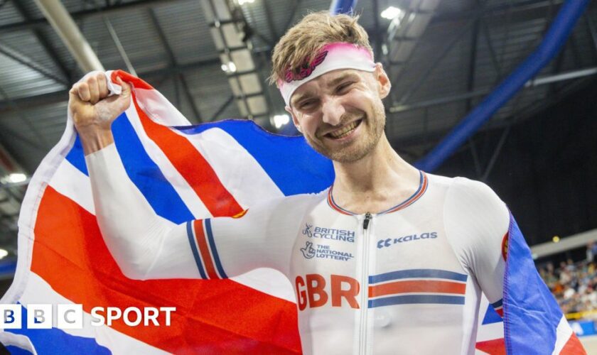 Dan Bigham holds the Union Jack after winning the individual pursuit at the European Track Cycling Championships in 2024