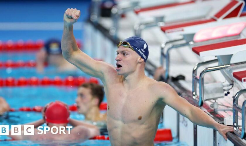 Leon Marchand celebrates winning gold