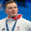 Adam Peaty holds his medal while crying