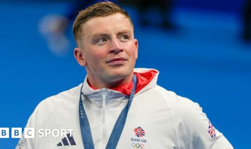 Adam Peaty holds his medal while crying