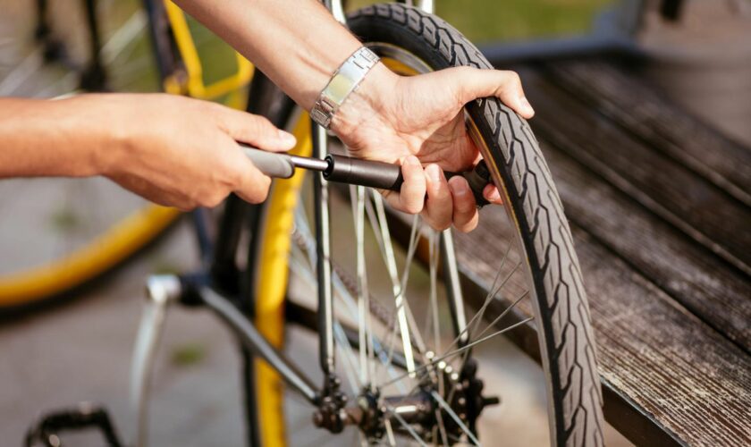 Mini-Fahrradpumpen im Vergleich: Mann pumpt Hinterrad mit Minipumpe auf