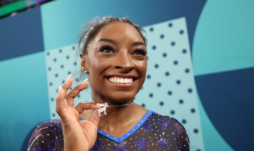 Simone Biles celebrates her gold medal with a diamond goat necklace