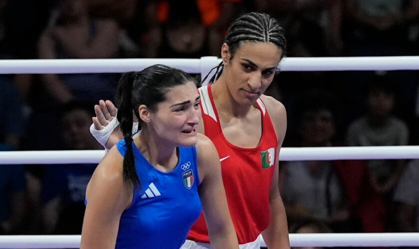 Algeria's Imane Khelif, red, next to Italy's Angela Carini, at the end of their women's 66kg preliminary boxing match at the 2024 Summer Olympics, Thursday, Aug. 1, 2024, in Paris, France. (AP Photo/John Locher)