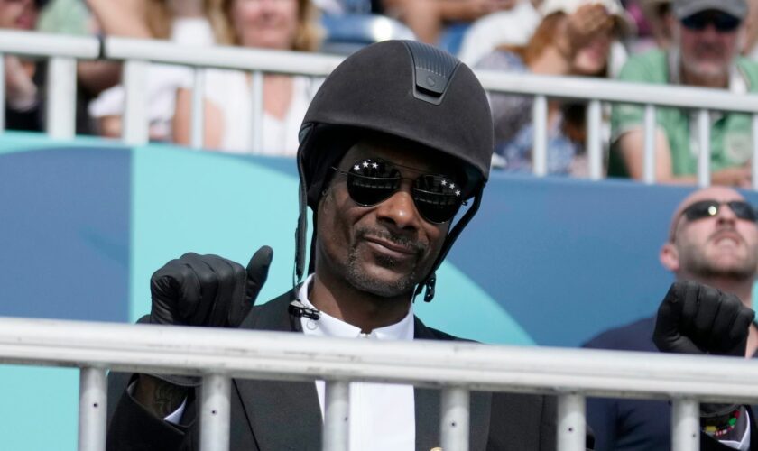 Snoop Dogg thumbs up as he watches the dressage team Grand Prix final at the 2024 Summer Olympics, Saturday, Aug. 3, 2024, in Versailles, France. (AP Photo/Mosa'ab Elshamy)