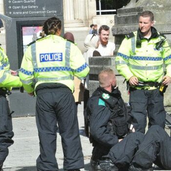 UK riots: Jeering Liverpool protesters surround injured female cop as library set ablaze