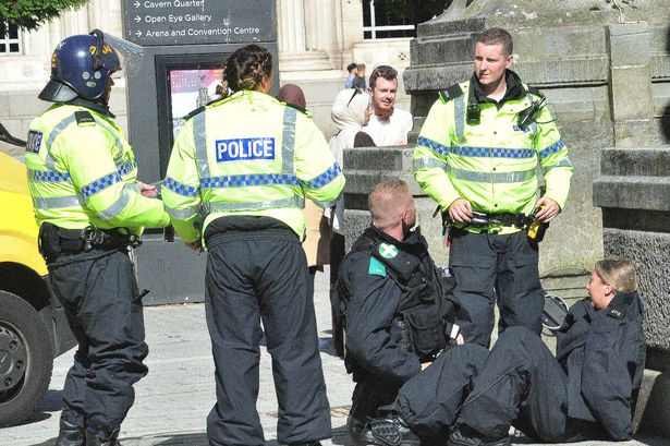 UK riots: Jeering Liverpool protesters surround injured female cop as library set ablaze