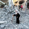 A Palestinian woman walks past destroyed houses at the site of an Israeli strike, amid the Israel-Hamas conflict, in Deir Al-Balah in the central Gaza Strip, August 7, 2024. REUTERS/Ramadan Abed.