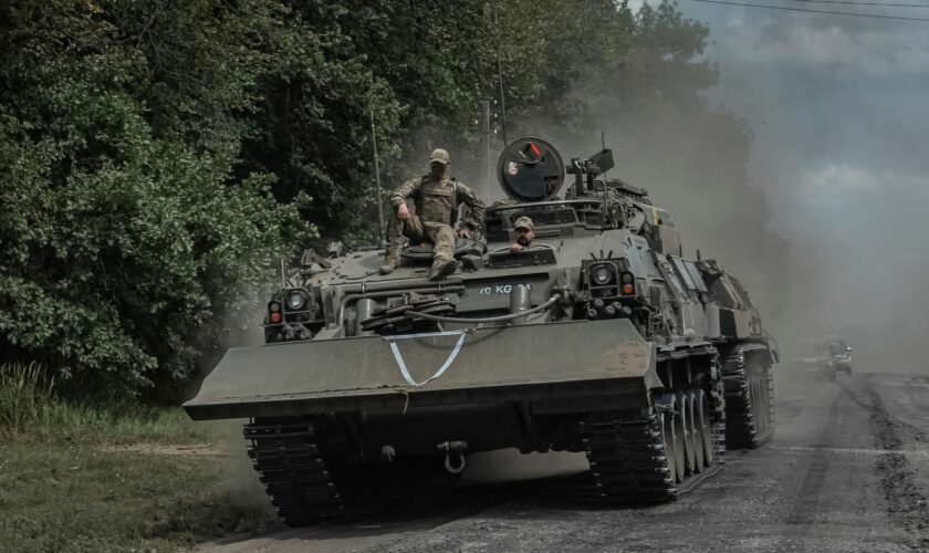 Ukrainian servicemen ride a military vehicle near the Russian border. Pic: Reuters