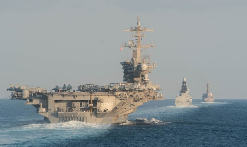 Le porte-avions USS Abraham Lincoln (G) passe le 19 novembre 2019 par le détroit d'Ormuz, dans le Golfe