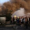 Volunteers and firefighters try to extinguish a fire in a building as a wildfire burns in Vrilissia near Athens, Greece, August 12, 2024. REUTERS/Alexandros Avramidis