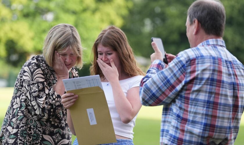 Hannah Greenwood reacts with her parents after receiving good A-level results at Solihull School in the West Midlands. Pic: PA