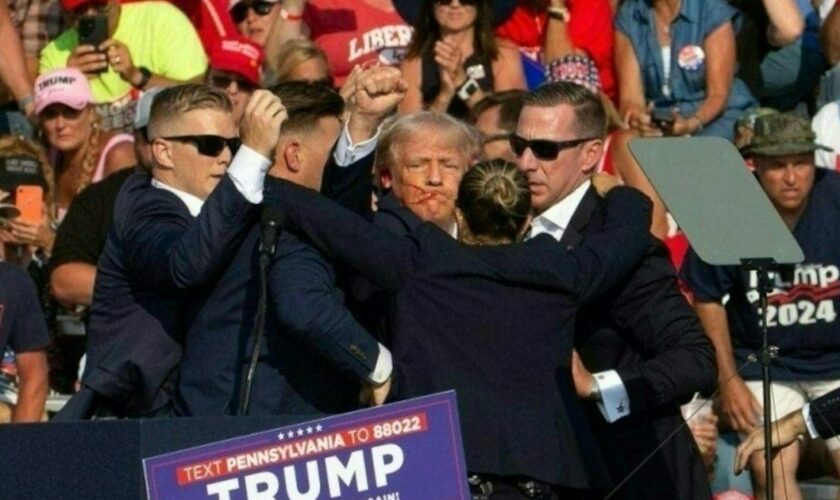 L'ex-président et candidat républicain Donald Trump entouré par des agents du Secret Service après avoir échappé à une tentative d'assassinat lors d'un meeting de campagne à Butler, aux Etats-Unis, le 13 juillet 2024