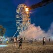 Festival-goers look on at the Ferris wheel fire. Pic: AP