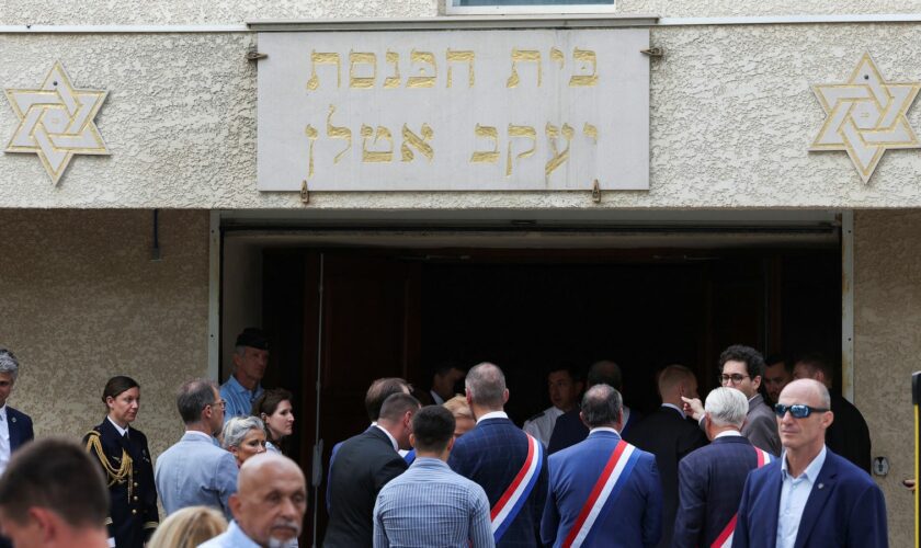 People stand by the entrance to the city's synagogue. Pic: Reuters