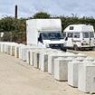 Travellers refuse to pay landowner to remove concrete bollards he used to block them into Isle of Wight car park - as stand-off enters second month