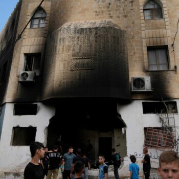 Palestinians outside a heavily damaged mosque in the West Bank. Pic: AP