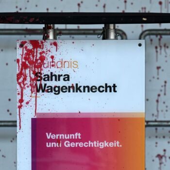 Mann spritzt rote Farbe auf Sahra Wagenknecht