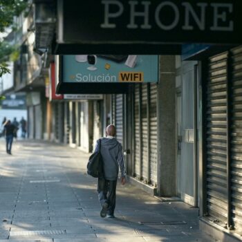 Des personnes passent devant des magasins fermés dans une rue de Caracas, au Venezuela, le 30 août 2024, à la suite d'une panne d'électricité généralisée