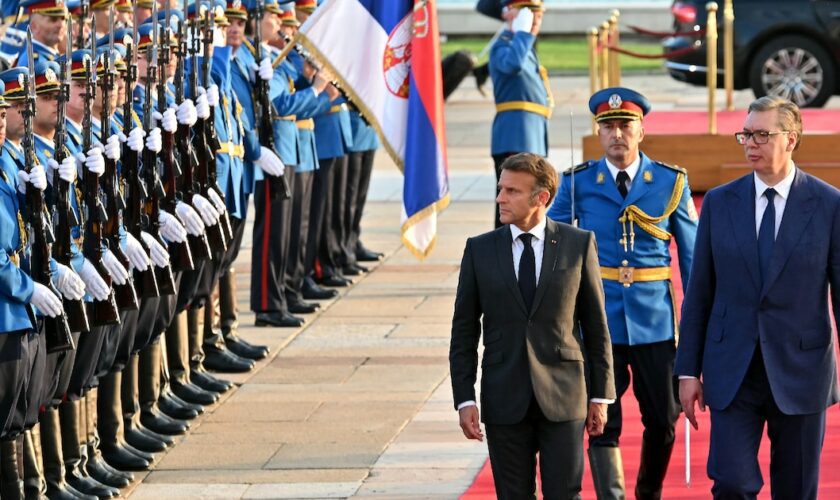 Le président français Emmanuel Macron et son homologue serbe Aleksandar Vucic (d) passent en revue la garde d'honneur, le 29 août 2024 à Belgrade