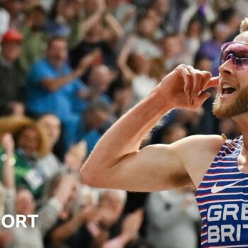 Josh Kerr celebrates winning the world indoor 3000m title in Glasgow by holding the Scottish flag