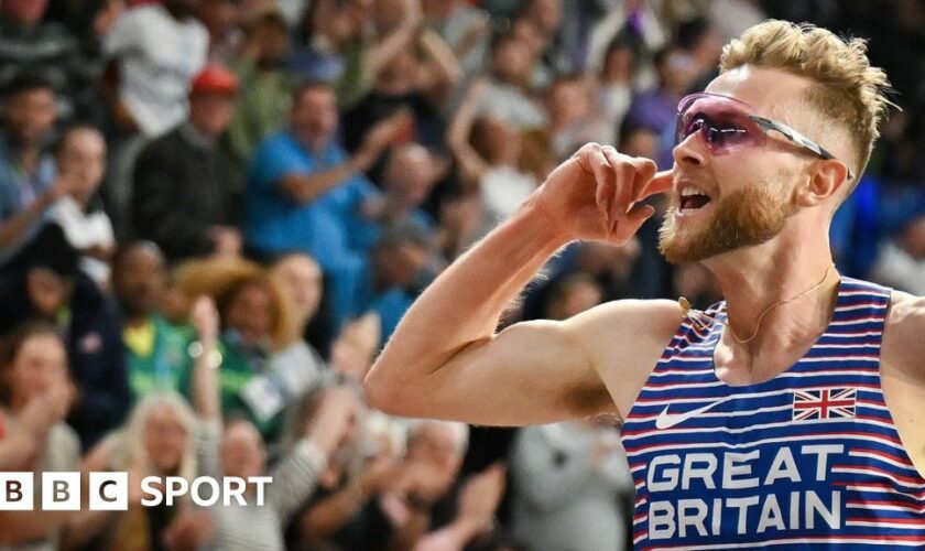 Josh Kerr celebrates winning the world indoor 3000m title in Glasgow by holding the Scottish flag